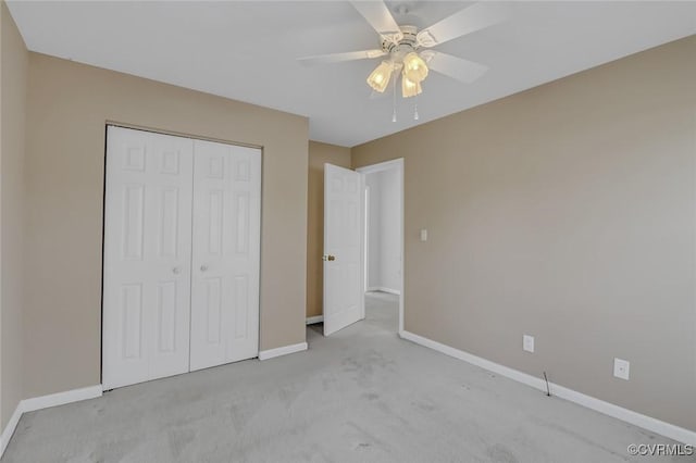 unfurnished bedroom with a closet, baseboards, carpet, and ceiling fan