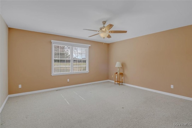 carpeted empty room with baseboards and a ceiling fan