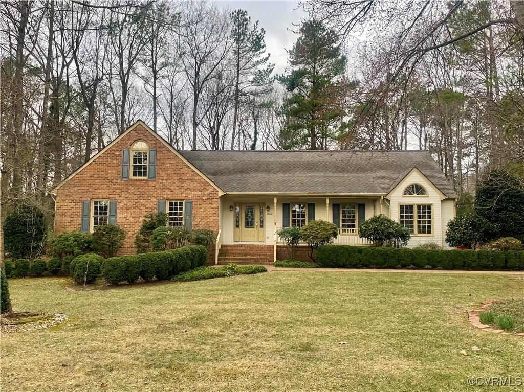 view of front facade featuring a front yard and brick siding