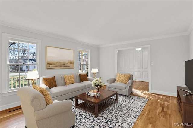 living room with visible vents, baseboards, wood finished floors, and crown molding