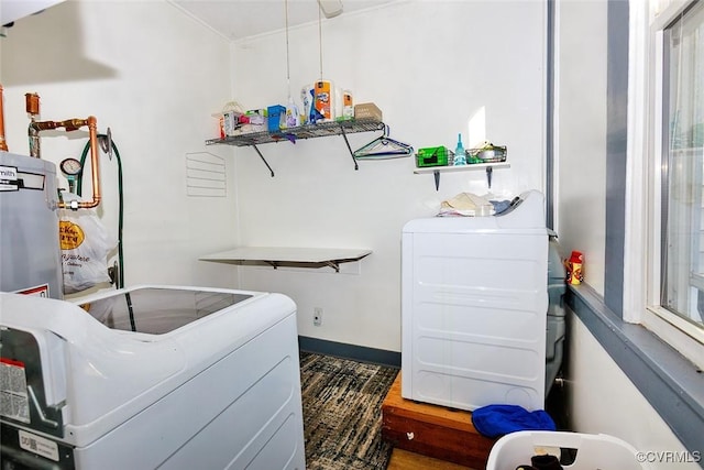 washroom with laundry area, separate washer and dryer, and baseboards