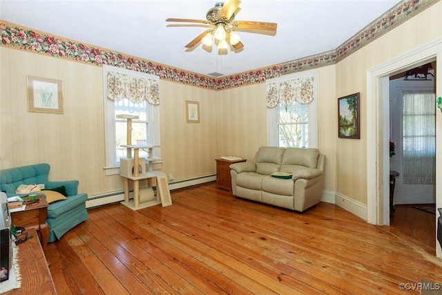 sitting room with light wood-style floors, a baseboard radiator, and a healthy amount of sunlight