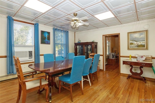 dining space with baseboards, a ceiling fan, an ornate ceiling, and light wood-style floors