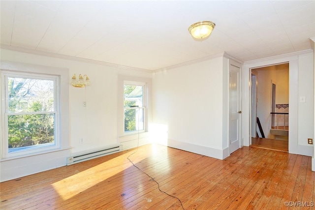 empty room featuring light wood-style flooring, ornamental molding, and baseboard heating