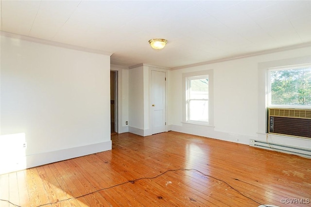 empty room with crown molding, baseboards, and hardwood / wood-style flooring