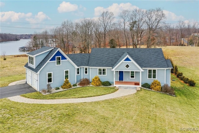 view of front of home featuring a garage, driveway, a front lawn, and a water view