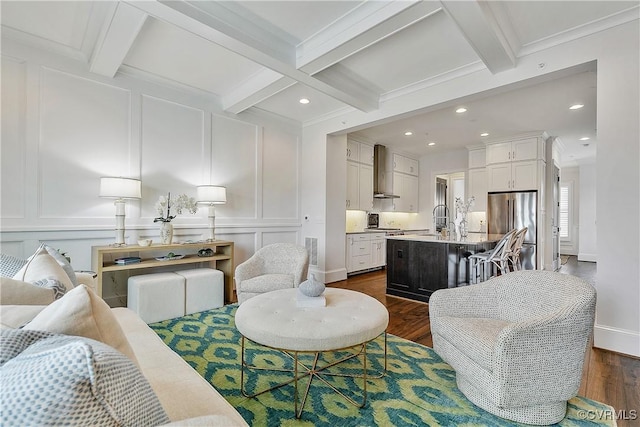 living area with dark wood-style floors, ornamental molding, a decorative wall, and beamed ceiling