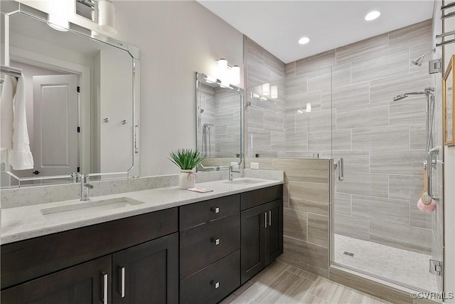 bathroom with a stall shower, a sink, recessed lighting, and double vanity