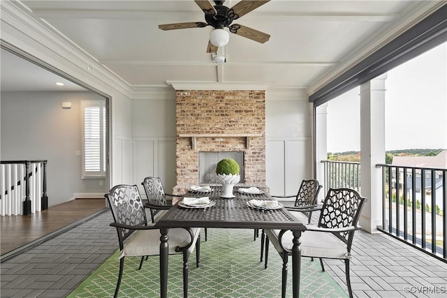 balcony with a brick fireplace, a ceiling fan, and a patio