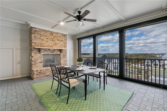 sunroom / solarium with ceiling fan and an outdoor brick fireplace