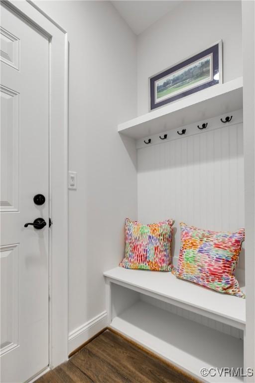 mudroom with dark wood-style flooring and baseboards