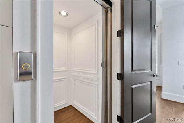 corridor featuring recessed lighting, wood finished floors, and baseboards