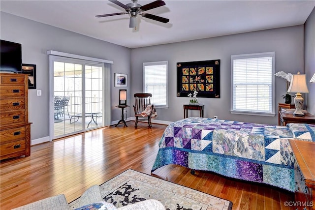 bedroom with access to exterior, a ceiling fan, baseboards, and wood finished floors