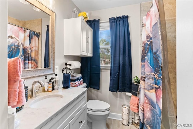 bathroom featuring toilet, curtained shower, baseboards, and vanity