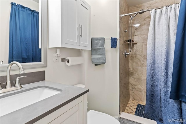 full bathroom featuring toilet, a shower stall, and vanity