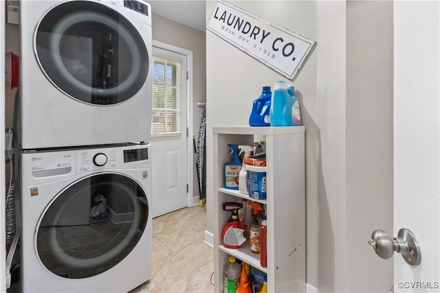 laundry area featuring laundry area, light tile patterned floors, and stacked washer / dryer