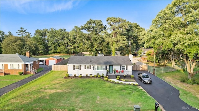 single story home featuring driveway, a front lawn, and fence