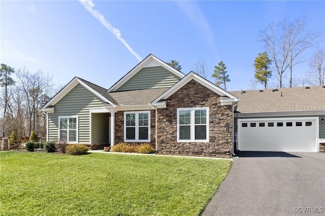 craftsman-style home featuring an attached garage, a front lawn, aphalt driveway, and roof with shingles