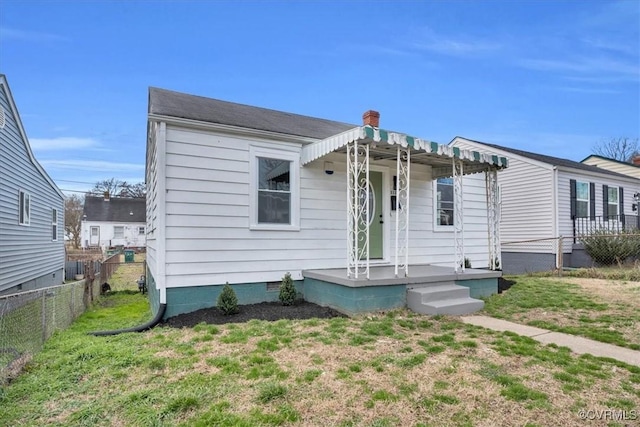 view of front facade featuring crawl space, fence, a chimney, and a front lawn