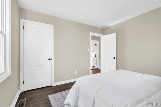 bedroom with visible vents, dark wood finished floors, and baseboards