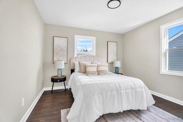 bedroom with dark wood-type flooring and baseboards