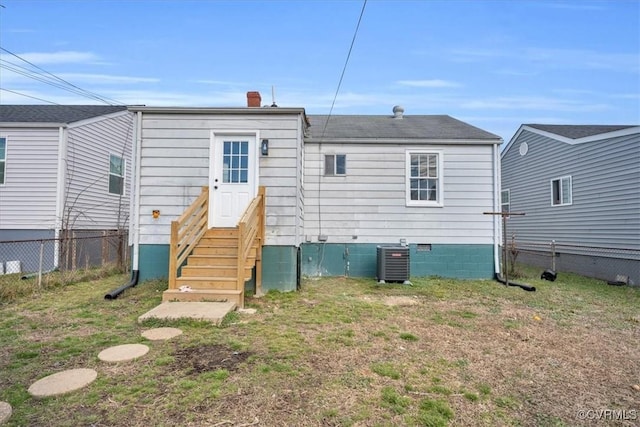 back of property featuring entry steps, fence, cooling unit, and a yard