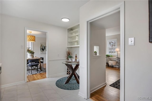 hallway featuring light wood-style flooring and baseboards