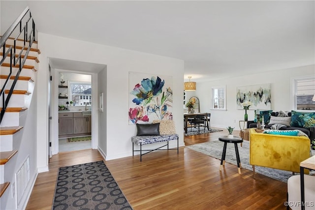 entrance foyer featuring light wood-style floors, baseboards, stairs, and visible vents