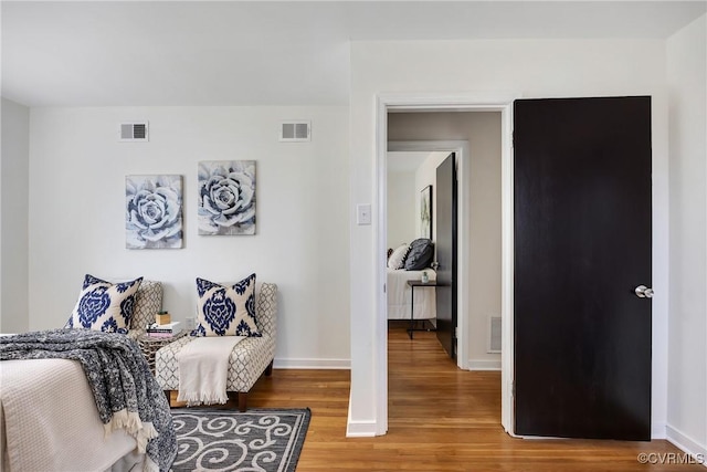 bedroom featuring wood finished floors, visible vents, and baseboards