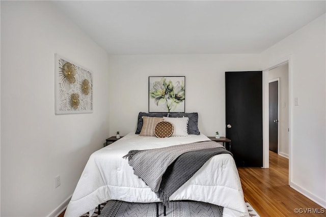 bedroom with wood finished floors and baseboards