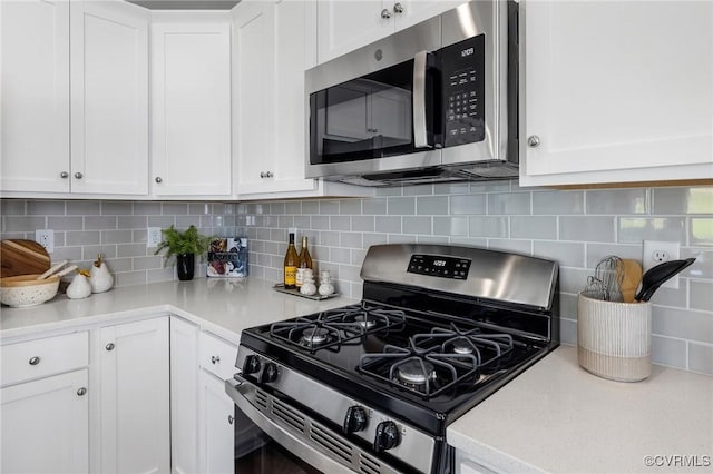 kitchen with tasteful backsplash, white cabinetry, appliances with stainless steel finishes, and light countertops