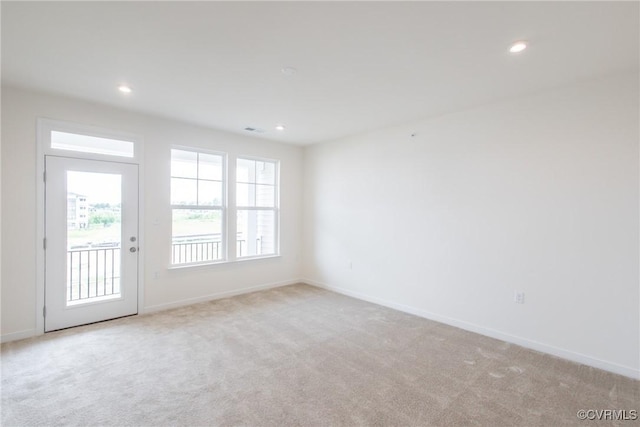 empty room featuring baseboards, recessed lighting, and light colored carpet