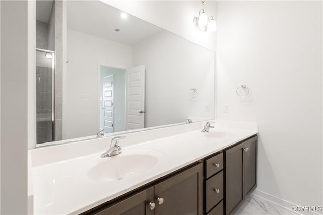 full bathroom with marble finish floor, a sink, baseboards, and double vanity