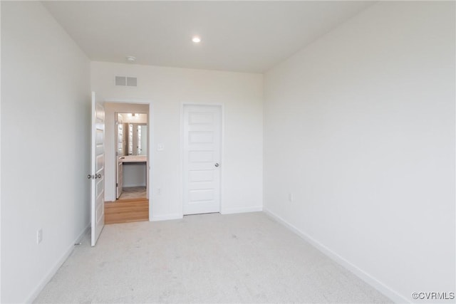 unfurnished bedroom with light carpet, recessed lighting, visible vents, and baseboards