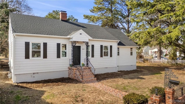 view of front facade featuring a shingled roof, crawl space, fence, and a chimney