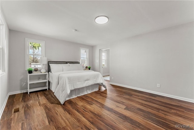 bedroom featuring baseboards, visible vents, and dark wood-type flooring