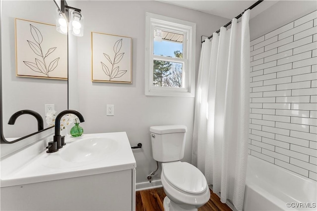 bathroom featuring toilet, wood finished floors, vanity, baseboards, and shower / bath combo