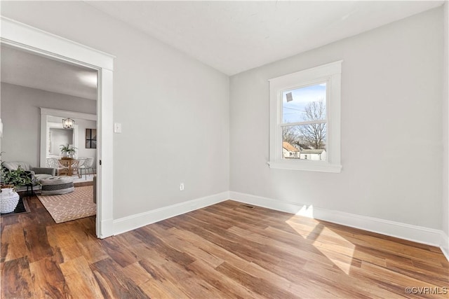 unfurnished room featuring baseboards and wood finished floors