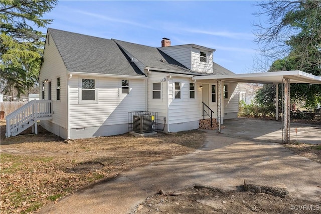 exterior space featuring crawl space, driveway, a chimney, and an attached carport