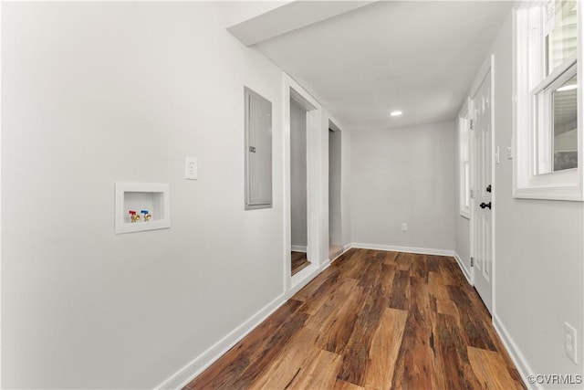 hall featuring dark wood-style flooring, electric panel, and baseboards