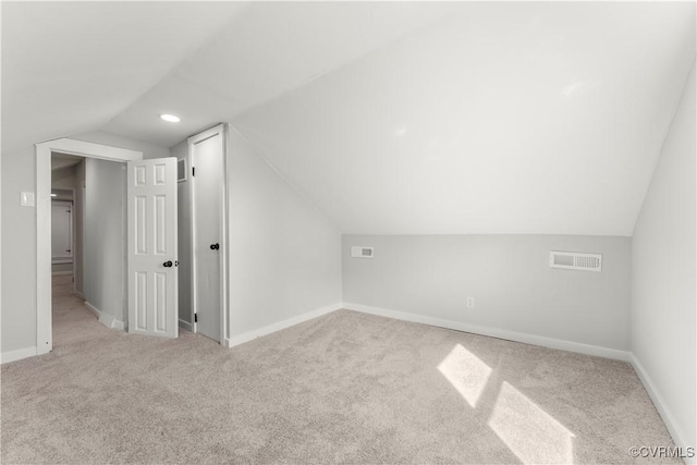 bonus room featuring lofted ceiling, carpet, visible vents, and baseboards