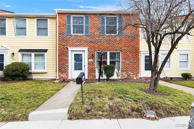 view of front facade with a front yard and brick siding