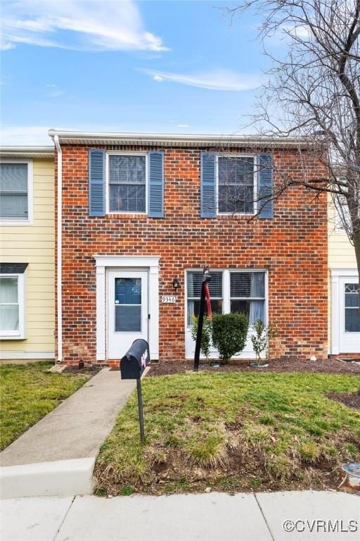 view of front of house with brick siding and a front yard