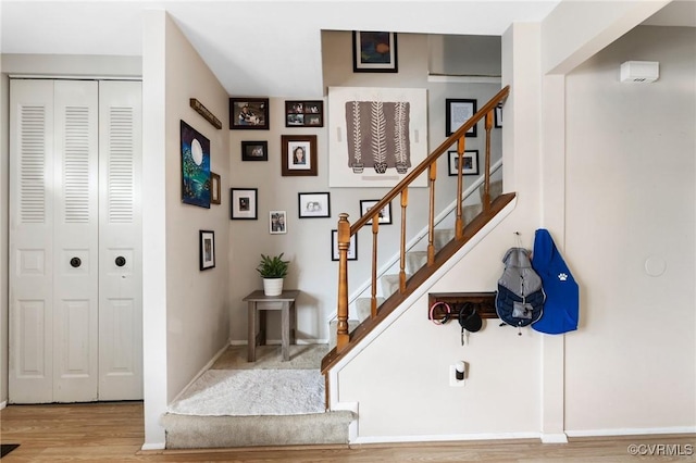 staircase with baseboards and wood finished floors