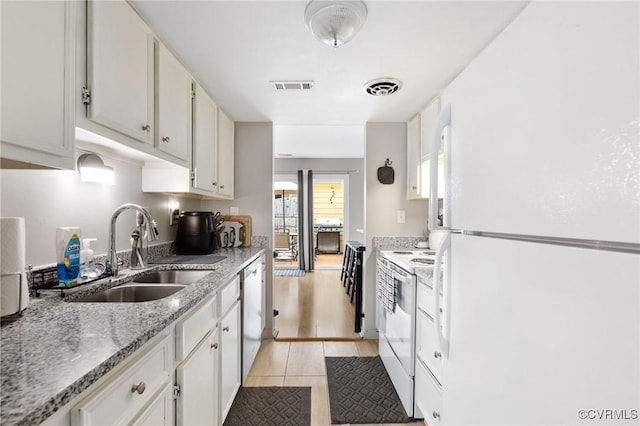 kitchen featuring white appliances, a sink, visible vents, and white cabinets