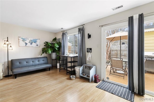 living area with visible vents and wood finished floors