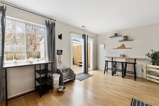 sitting room with baseboards, visible vents, and wood finished floors