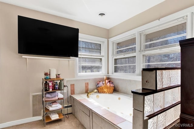 bathroom with a garden tub, baseboards, visible vents, and baseboard heating