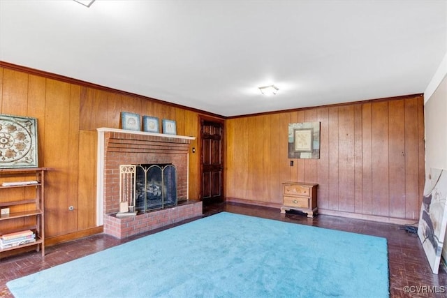 unfurnished living room featuring a brick fireplace and wooden walls