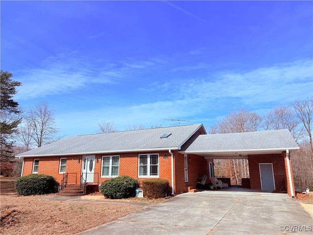 ranch-style home featuring an attached carport, concrete driveway, and brick siding